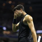 Imagem colorida de Carlos Alcaraz com a mão no rosto - Metrópoles